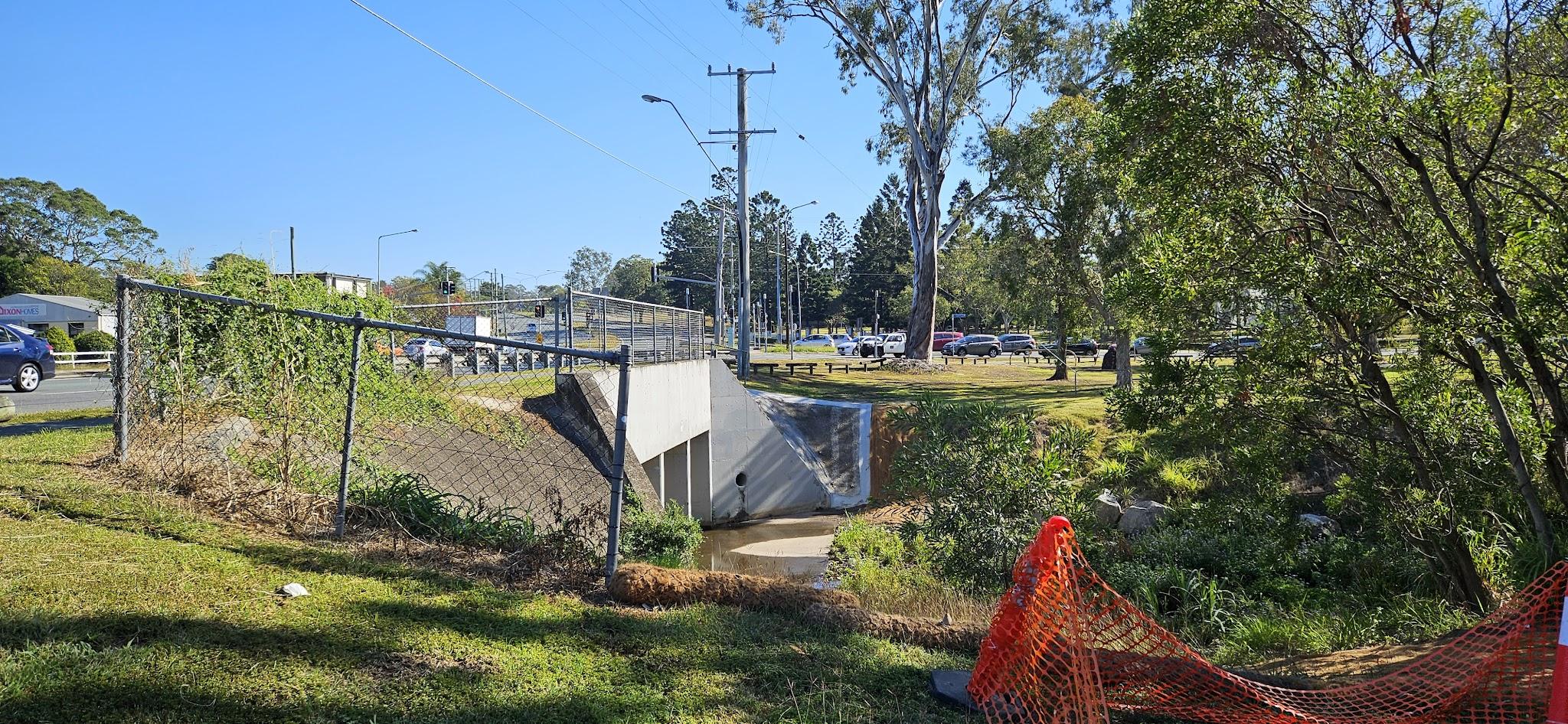 The eastern side of the bridge over Downfall Creek. The cars in the background are on Murphy Road, waiting for the lights at Gympie Road.